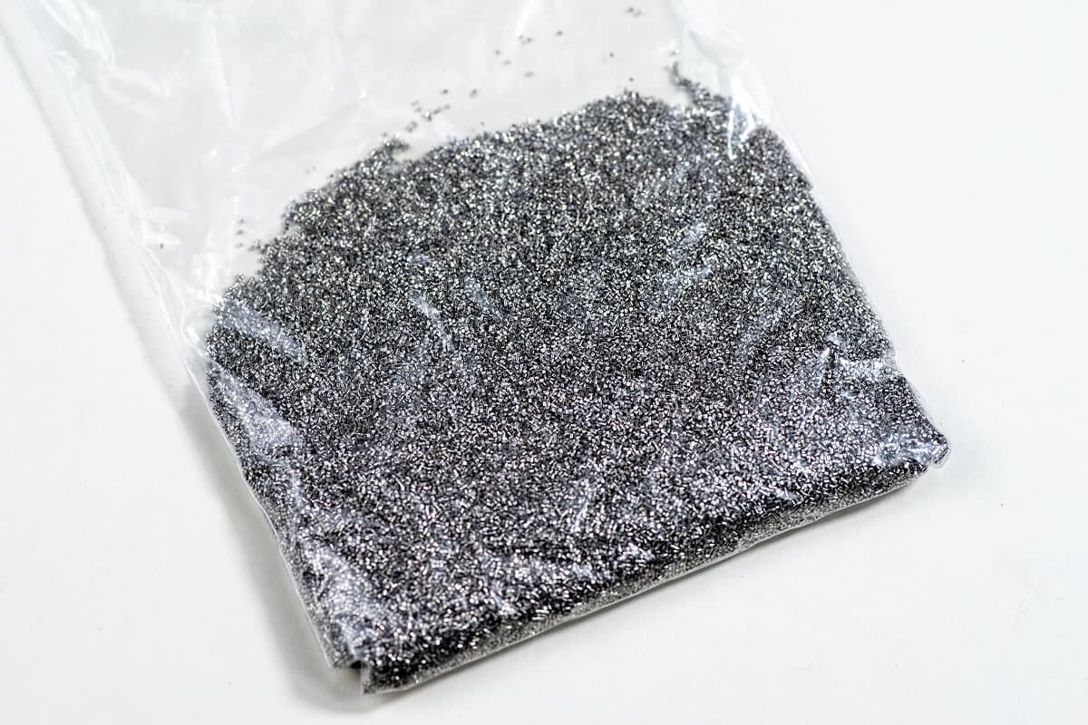 Clear plastic bag filled with steel shot abrasive media used for shot blasting applications.